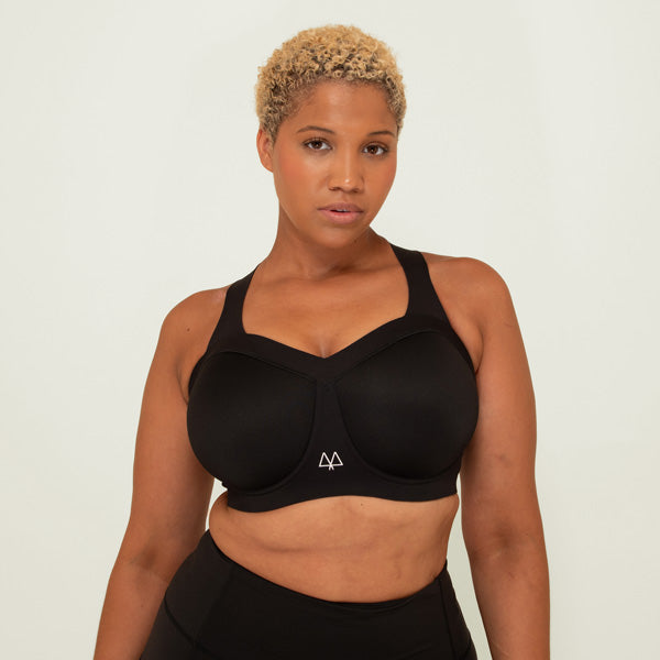 Woman wearing a black sports bra and leggings on a white background