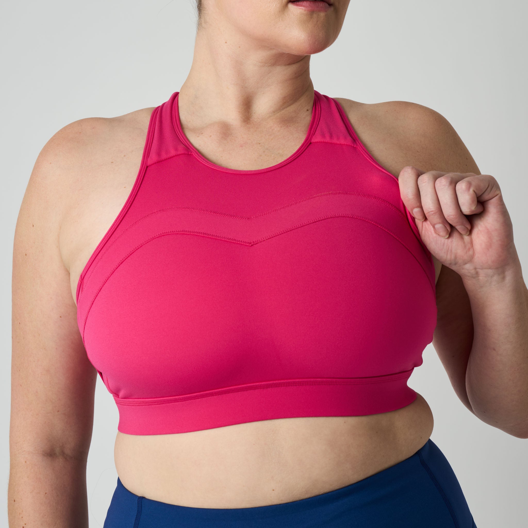 Person wearing a bright pink sports bra against a neutral background