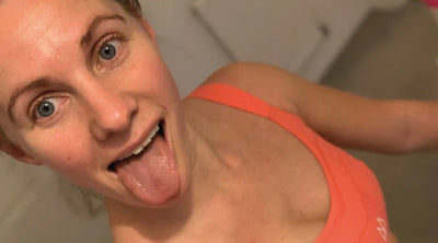 Girl sticking her tong out whist wearing a coral maaree sports bra