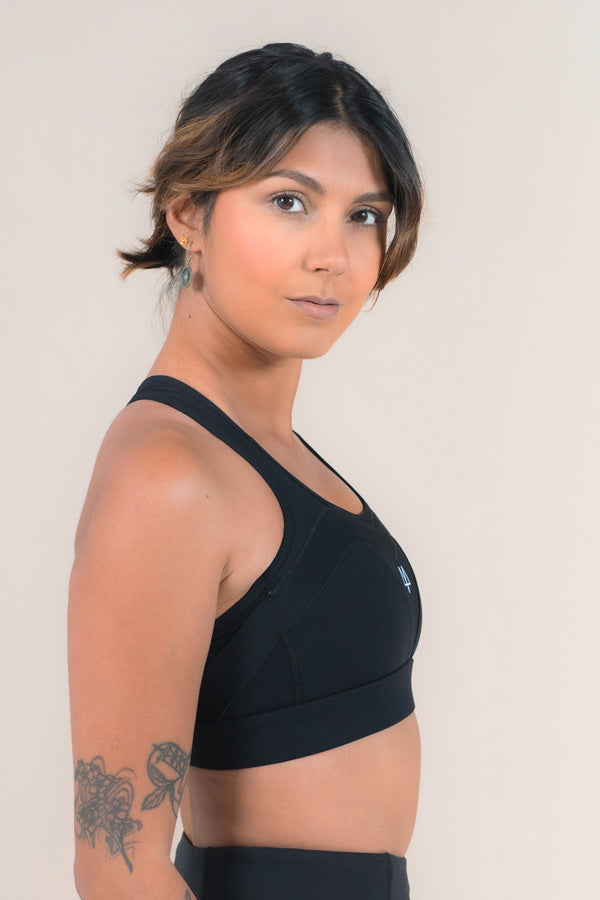 Woman standing side on showing her MAAREE Sports bra in Black